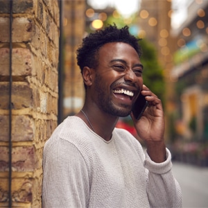 Happy man using his phone outside.