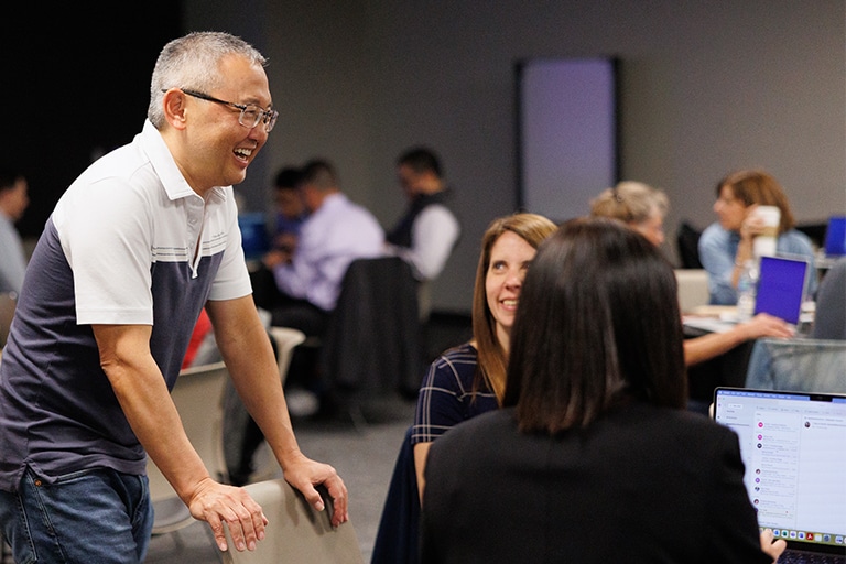 Bamboo Insurance employees laughing and interacting in a large meeting space.