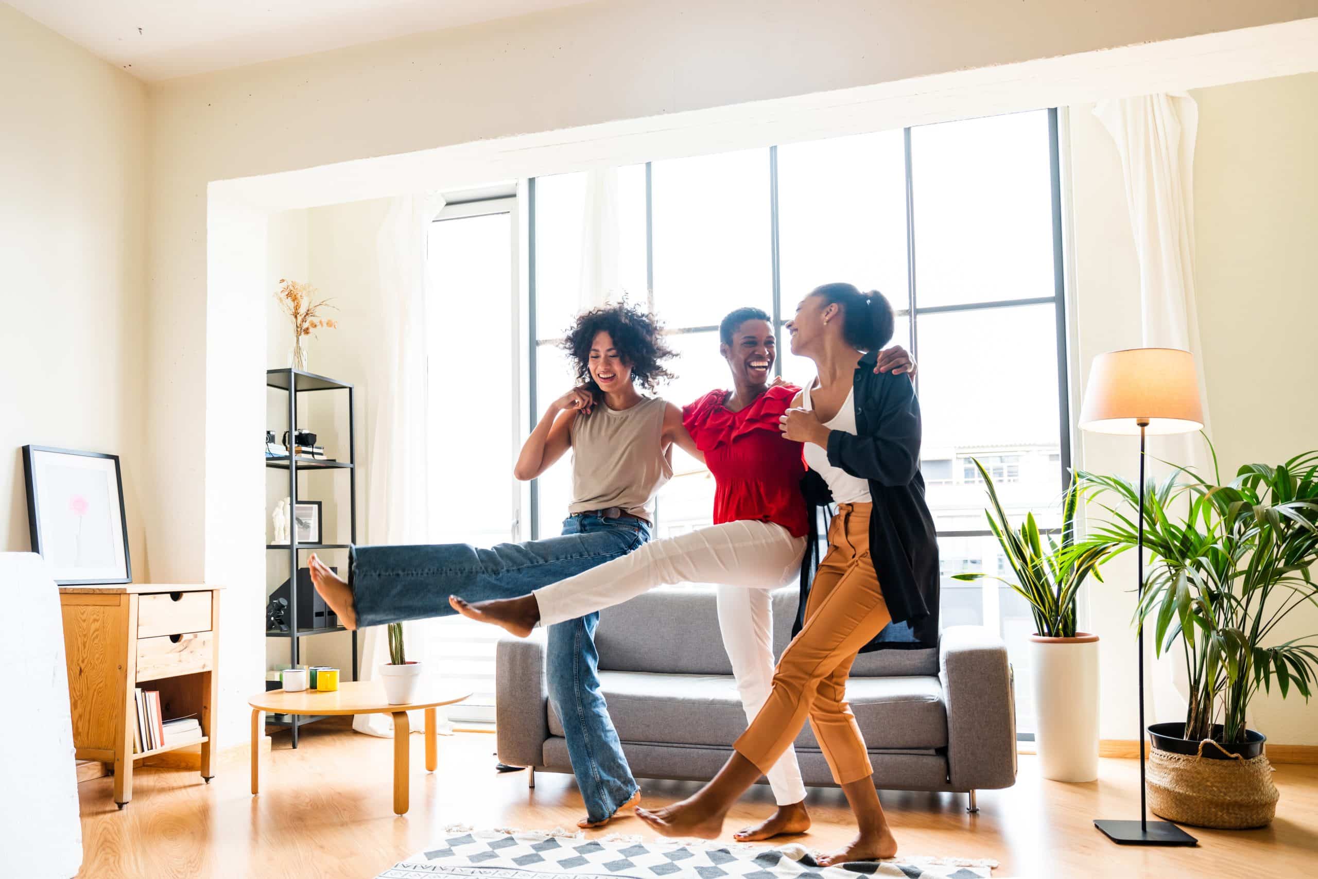 Three women laughing and spending time together indoors.