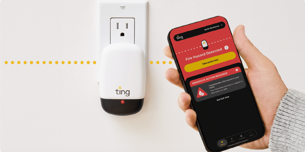 A ting sensor is plugged into the wall with someone holding a phone with the app open.
